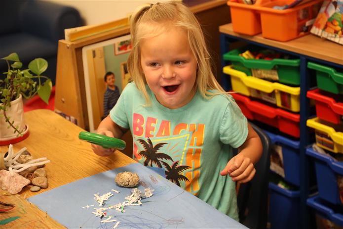  Childs face full of excitement as she makes a discovery in the classroom